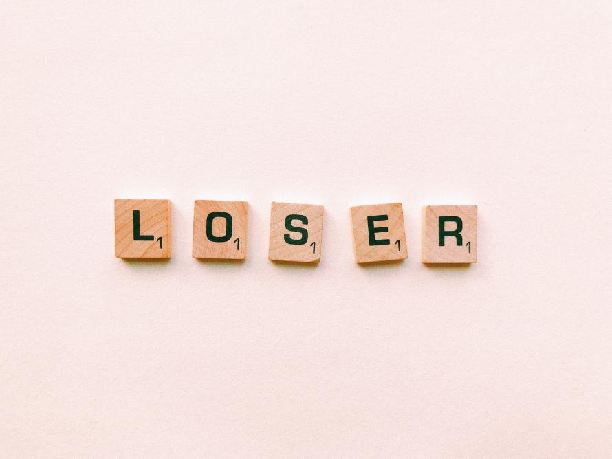 Scrabble pieces spelling the word “LOSER”.